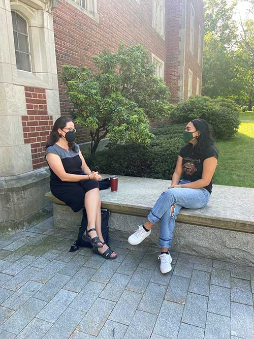 student and professor sitting outside